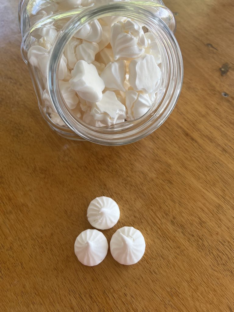 meringues dans un bocal et 3 meringues sur une plaque en bois