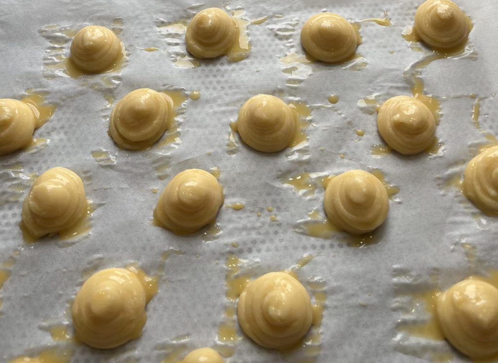 chouquettes pochées et dorées sur du papier cuisson