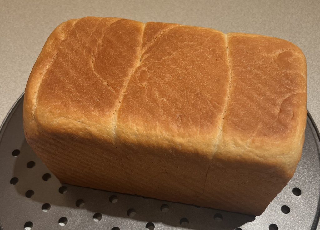 Pain de mie démoulé et posé sur une grille de refroidissement