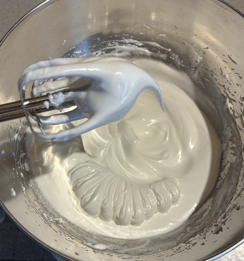 bec d'oiseau pour meringue une fois que le sucre est ajouté aux blancs. l'appareil est dans un cul de poule en inox