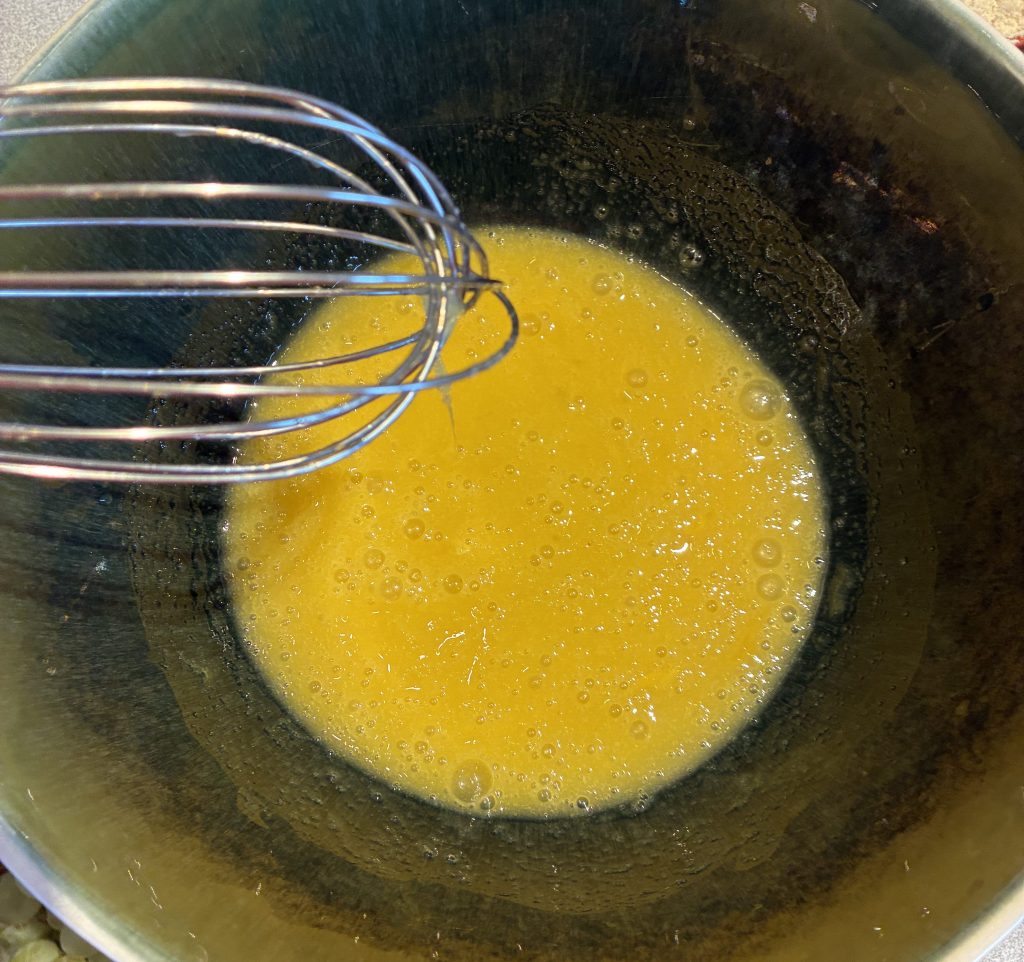 sucre et oeufs après mélange dans un saladier de couleur verte