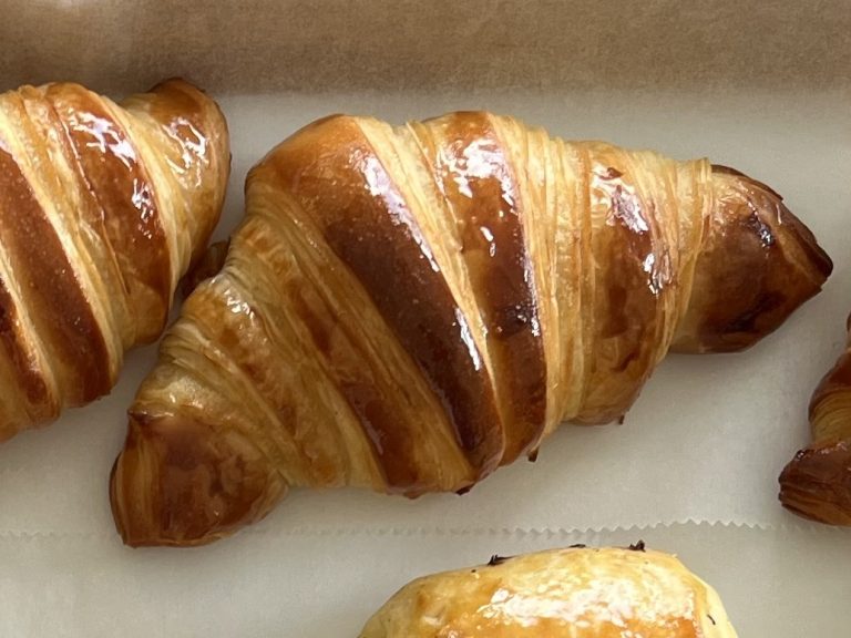 croissants maison sur plateau de viennoiserie en bois blanc