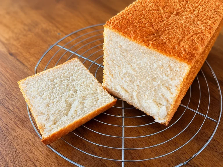 pain de mie maison moelleux qui refroidit sur une grille, posée sur une table en bois